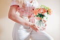 Close up of vase in female hands with bouquet of fresh flowers. Floral arrangement with orange roses Lady of Shallott Royalty Free Stock Photo