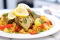 close-up of vegan paella with artichokes and beans on white plate Royalty Free Stock Photo