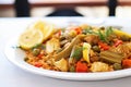 close-up of vegan paella with artichokes and beans on white plate Royalty Free Stock Photo