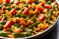 Close-up of vegan paella in a traditional pan, vibrant with bell peppers, peas, and artichokes. AI generated. Royalty Free Stock Photo