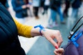 Close up of venezuelan woman hands wearing blue ribbon in support of president Juan Guaido during coup attempt