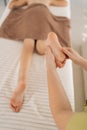 Close-up vertical cropped shot of unrecognizable orthopedic doctor doing orthopedic leg exercises of teenager girl Royalty Free Stock Photo