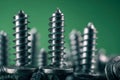 Macro photo of galvanized steel screws standing upright with a blurred green background showcasing metal texture and sharp Royalty Free Stock Photo
