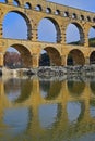 Close up vertical image of three arch level of Pont du Gard with clear reflection on Gardon River Royalty Free Stock Photo