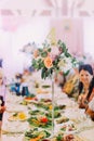 Close-up vertical photo of the beautiful bouquet of colourful roses and peonies on the wedding table set.