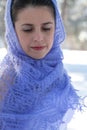 Close-up vertical portrait against the background of the winter forest of a pensive girl in a beautiful light purple knitted shawl Royalty Free Stock Photo