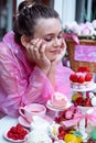 Close up vertical smiling dreaming teenage girl in pink raincoat joy and looking at sweet berry desserts in outdoor cafe Royalty Free Stock Photo