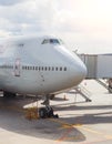 Close-up of very large wide-body airplane being prepared for towing, with tow-truck connected. Royalty Free Stock Photo