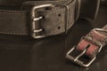 Close-up of very old genuine leather collars on a dark table