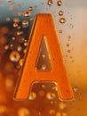 Close-up of a vibrant amber-colored letter \