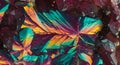 Close-up of a vibrant, multicolored crystal formation with angular, overlapping facets