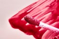 Close-up of vibrant pink lip gloss applicator with textured brush and background Royalty Free Stock Photo