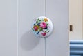 Close-up at Victorian style round porcelain floral door knob on white wooden barn style door Royalty Free Stock Photo