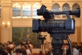 Close-up of a video camera in a conference room against the background of people Royalty Free Stock Photo