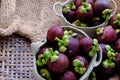 Close up fresh Mangosteens fruit in handbag on burlap background