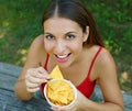 Close up view from above of beautiful young woman eating tortilla chips outdoor