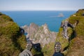 Man sitting on the edge of a cliff. The view of the feet in sports shoes is necessary to the abyss overlooking the rocks and the Royalty Free Stock Photo