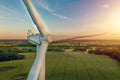 Close up view from above of a wind turbine for renewable green electricity with green rural landscape, silos on the background. Royalty Free Stock Photo