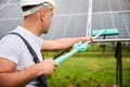 Close up view of adult worker cleaning PV battery by mop.