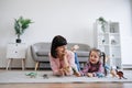 Mother and child being engaged in dinosaur play in lounge