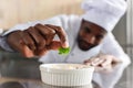 Close-up view of african american chef garnishing dish Royalty Free Stock Photo