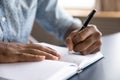 Close up view of african left-handed businessman writing in notebook Royalty Free Stock Photo