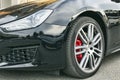 Close up view aggressive sport front design and front light of Maserati Ghibli car in gunmetal color, produced by Italian