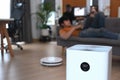 Close up view of Air purifier in living room and man lying on sofa in background