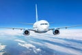 Close up view airplane in flight. Passenger jet plane in the blue sky. Aircraft flying high through clouds Royalty Free Stock Photo