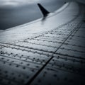 A close-up view of an airplane wing with visible rivets and smooth, metallic surface. Royalty Free Stock Photo
