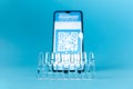 Close up view ampules with vaccines and blurred smartphone with electronic Immunity passport. Blue background. Concept of