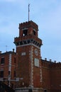 Close-up view of ancient red brick tower with sun clock. Gates of the Arsenale, Venice, Italy. Travel and tourism concept Royalty Free Stock Photo