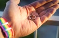 close-up view of a man& x27;s hand showing a ring with an LGBT rainbow wristband.