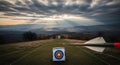Archery Target in Dramatic Sunset Landscape with Arrow in Foreground Royalty Free Stock Photo