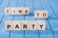 close up view of arranged wooden blocks into time to party phrase on blue