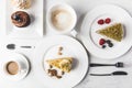 Close up view of arrangement of pieces of various cakes on plates, cups of coffee and cupcakes