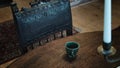 Close up view of artisanal tea cup on wooden table with old vintage wood royal armchair interior design