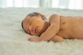 Close up view of Asian young newborn baby is sleeping and smile on white bed in the bedroom with soft light Royalty Free Stock Photo