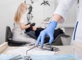 Close-up view of assistant`s hands with blue gloves working with dental equipment