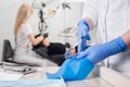 Close-up view of assistant`s hands with blue gloves working with dental tools