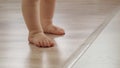 Close up view of babies feet during making her first steps slow motion