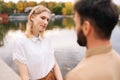 Close up view from back of unrecognizable bearded man to cheerful woman standing holding hands with boyfriend outdoors Royalty Free Stock Photo