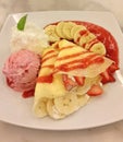 Close-up view of banana crepe with fresh strawberry and strawberry sauce together with strawberry ice cream and whip cream Royalty Free Stock Photo