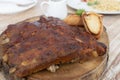 Close up view of barbecue ribs with and sauce on wooden table. Pork ribs on a wooden plate. Hot grilled spare ribs served with bre Royalty Free Stock Photo