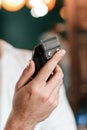 Close up view of barber hand that is holding hair clipper