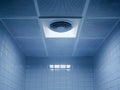 Pathogens on bathroom exhaust fans Pathogens, close-up view of a bathroom ceiling featuring a vent and tiles, showcasing cool blue Royalty Free Stock Photo