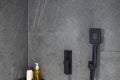 Close up view of bathroom interior. grey ceramic tile wall with plumbing equipment. Royalty Free Stock Photo