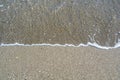 Close up view of beach with a sea wave, small stones, sand and shells Royalty Free Stock Photo