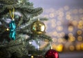 Close up view of beautiful fir branches with shiny golden bauble or ball, xmas ornaments and lights, christmas holidays background Royalty Free Stock Photo