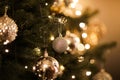 Close up view of beautiful fir branches with shiny golden bauble or ball, xmas ornaments and lights, Christmas holidays Royalty Free Stock Photo